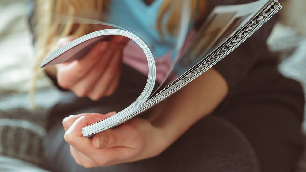 a decorative element: a photo of a woman looking through a magazine