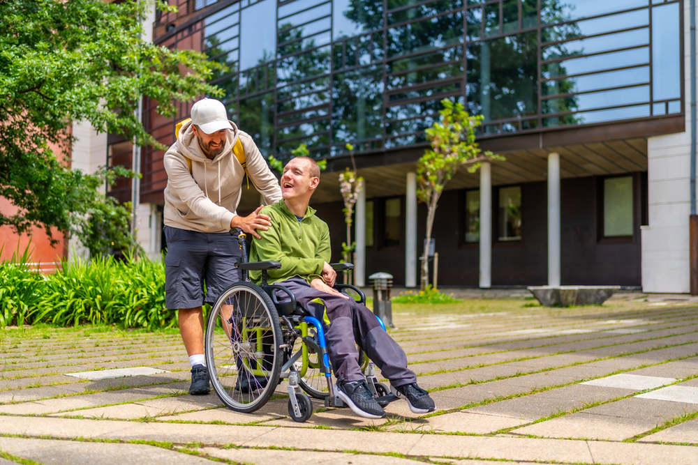 A man with special needs and his friend walking around a university campus.