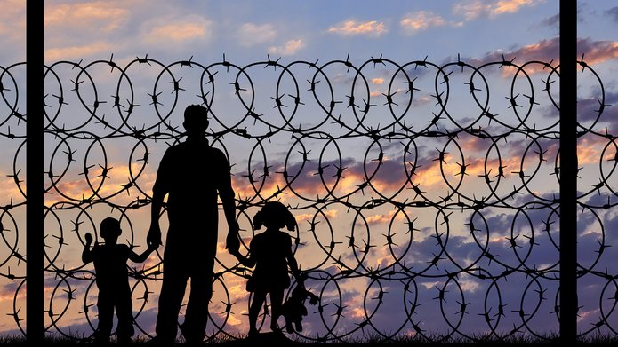 ludzie na tle drutu kolczastego