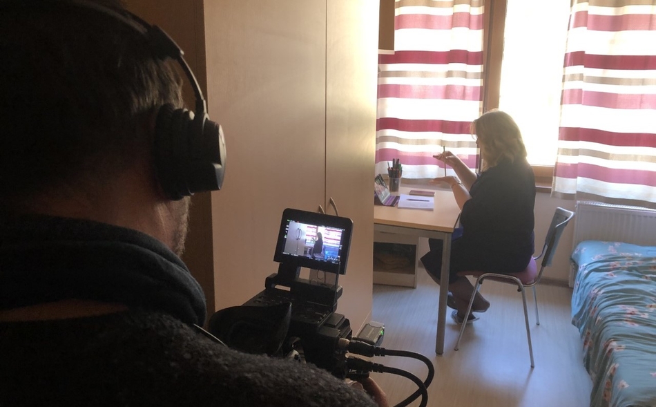 A woman with a laptop sitting at a desk in the room