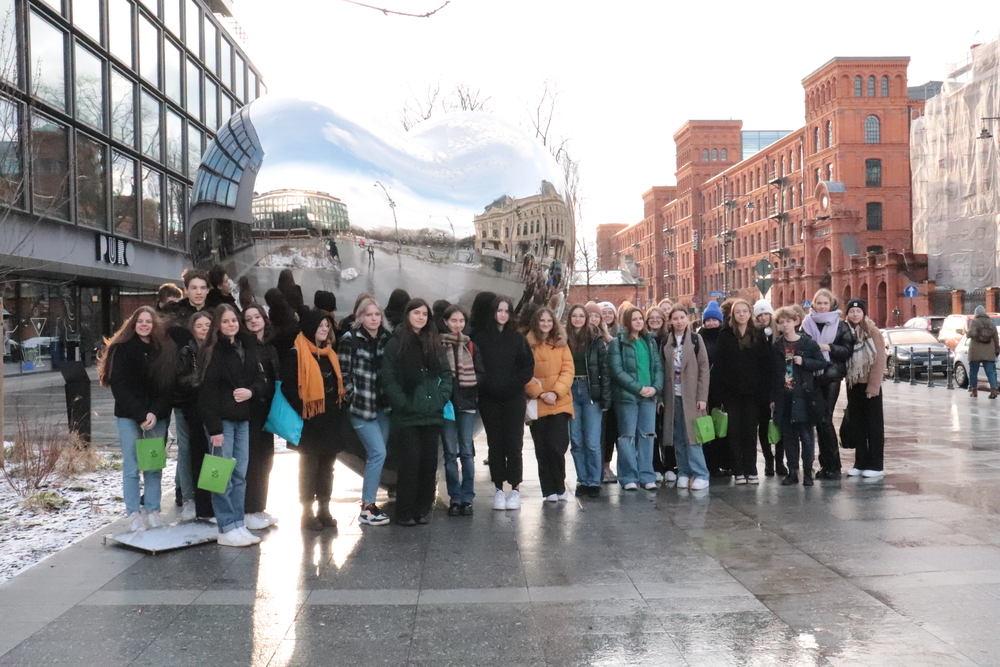 A group of high school students on the background of a silver heart in Lodz
