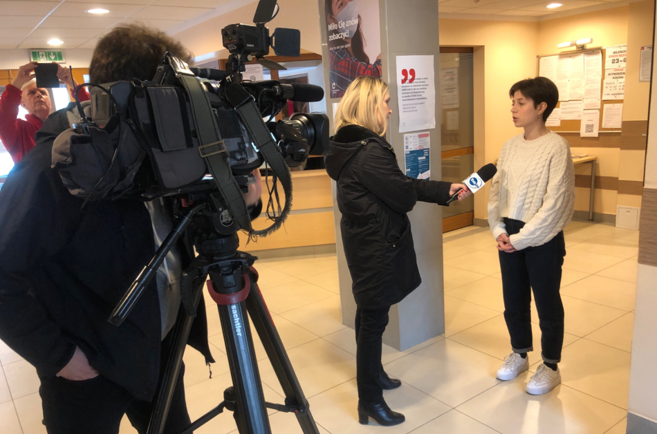 TV crew with a camera talking to a young woman