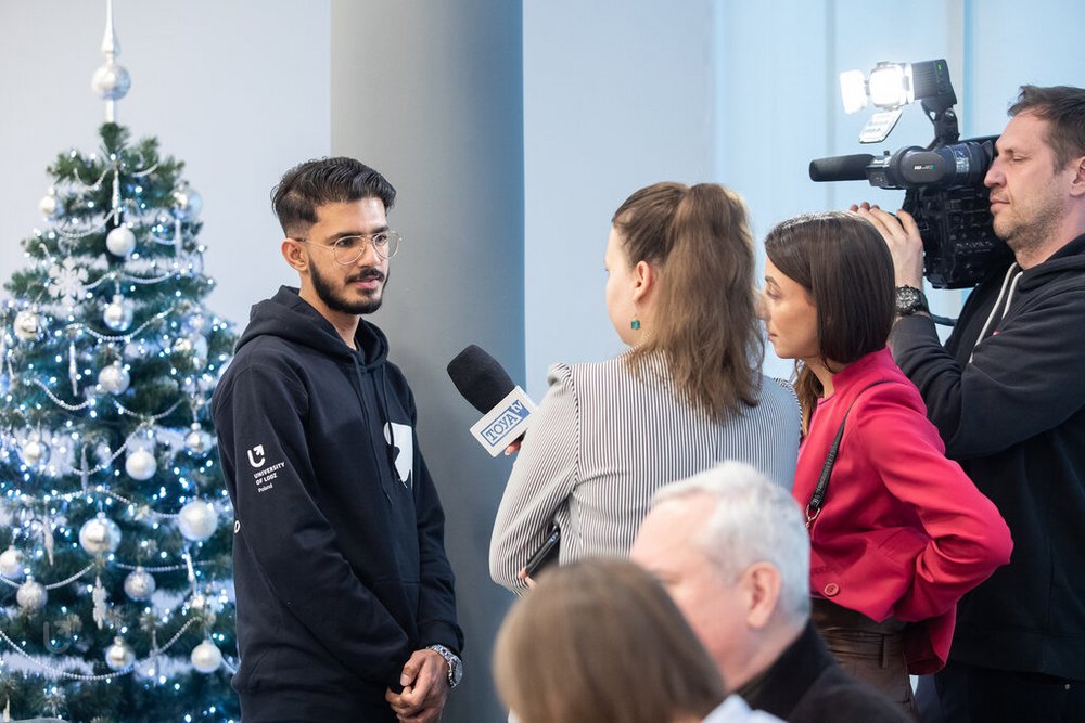 student w czarnej bluzie UŁ podczas wywiadu do telewizji TOYA